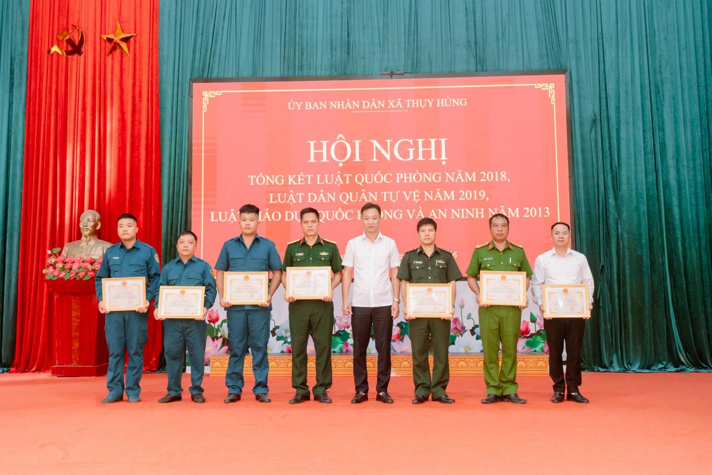 Có thể là hình ảnh về một hoặc nhiều người và văn bản cho biết 'ỦY İYBANNHANDÂNXÄTHYYHUNG BAN NHÂN DÂN XÃ THỤY HỪNG LUÂT HỘI NGHỊ TÔNG KẾT LUẬT QUOC PHÒNG NĂM 2018, LUẬT DÂN QUÂN TỰ VỆ NĂM 2019, ÁO DU DLORUÓC QUỐC NG VÀ AN NINH AM M 2013 노구토 าง 頭必丽'