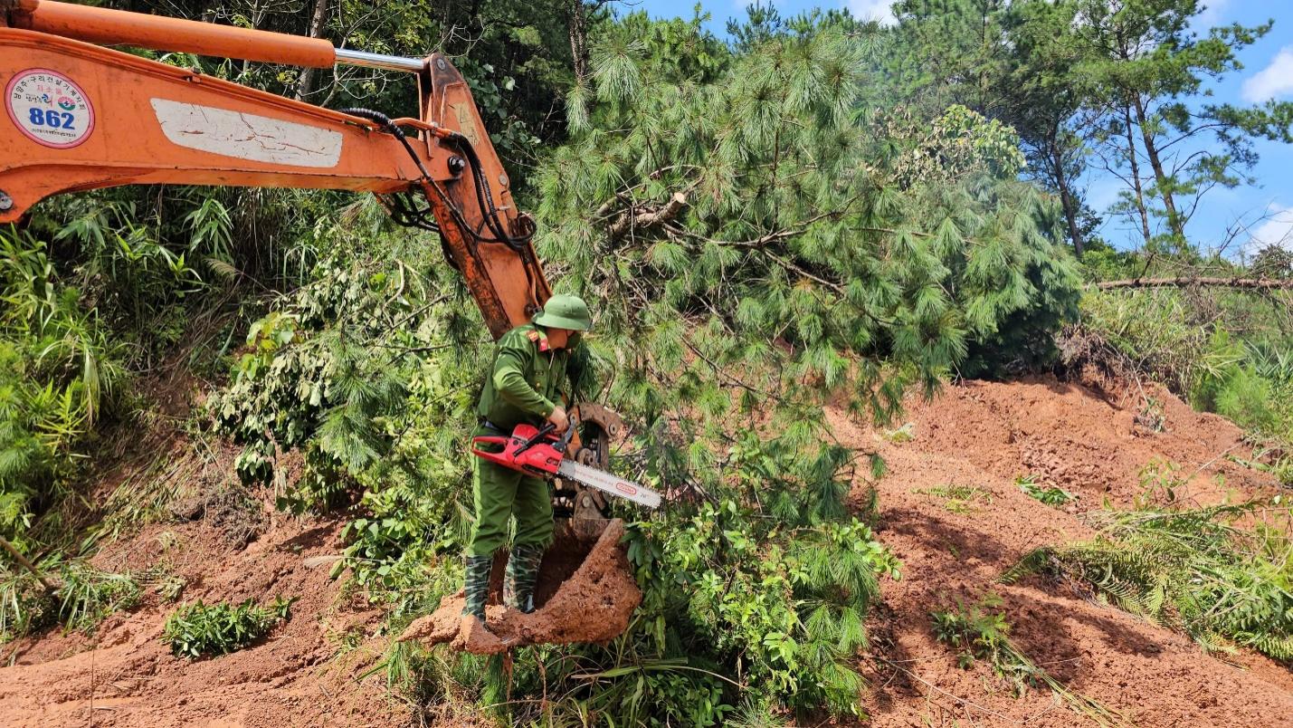 A person in green overalls holding a chainsaw in a pile of dirt

AI-generated content may be incorrect.